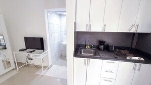 Una cocina moderna con armarios blancos, encimera negra y un lavabo.