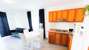 Una cocina compacta con comedor, sofá y una pequeña mesa.