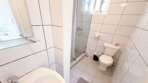 A bathroom with a white sink, toilet, and shower area. - Los Corales COCOS Suites HOTEL POOL&SPA (Bavaro)