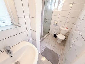 Ein Badezimmer mit Waschbecken, Toilette und Duschbereich.