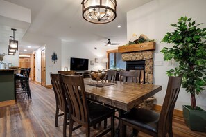 A dining area with a wooden table, chairs, and a chandelier. - AL4203 | Beautiful and Professionally Decorated | 10 Hot Tubs | Air Chilling (Steamboat Springs)