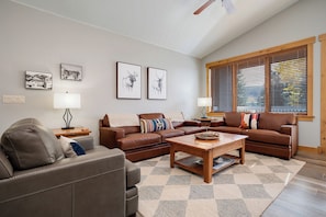 A living room with two brown leather sofas, a coffee table, a patterned rug, and a window with blinds. - AL4205 | Home Away from Home | Modern Décor | Air Chilling | Close to Slopes (Steamboat Springs)