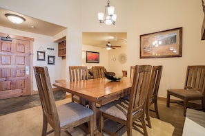 A dining area with a wooden table and chairs, a ceiling fan, and a chandelier. - AL4304 | Top Floor with Vaulted Ceilings | Views | 4 Pools | Air Chilling (Steamboat Springs)