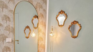 A room with a round table, a chair, and a mirror on the wall. - Arcadia Rooms Palermo (Palermo)