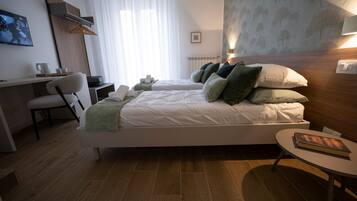 A modern hotel room with a bed, a desk, and a chair.