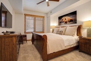 A bedroom with a wooden bed, a desk, a chair, a television, and a window with blinds. - BL6108 | Ultimate Vacation Experience | Private Hot Tub | Air Chilling | Pools (Steamboat Springs)