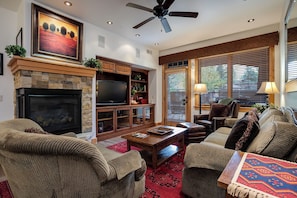 A living room with a fireplace, television, and seating area. - BL6110 | Beautifully Appointed Mtn Condo | Private Hot Tub | Air Chilling | Pool (Steamboat Springs)