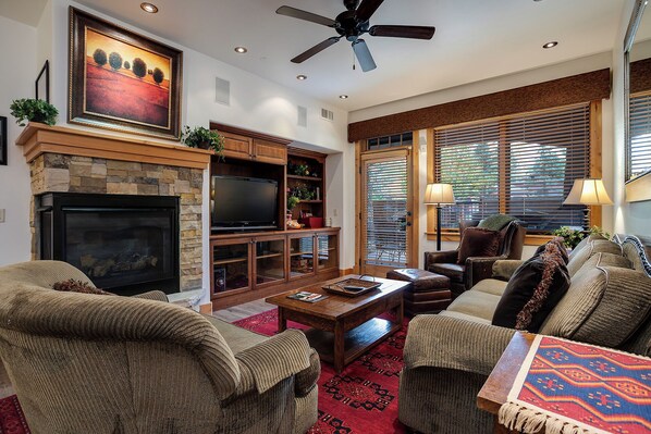 A living room with a fireplace, television, and seating area. - BL6110 | Beautifully Appointed Mtn Condo | Private Hot Tub | Air Chilling | Pool (Steamboat Springs)