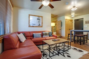 A living room with a leather sofa, a coffee table, and a ceiling fan. - BL6113 | Gorgeous Condo | Easy Walk to Slopes | 10 Hot Tubs | Winter Shuttle (Steamboat Springs)