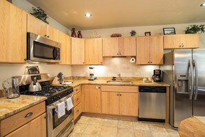 A modern kitchen with wooden cabinets, stainless steel appliances, and a granite countertop. - BL6115 | Unique and Beautiful Getaway | Heated Garage| Hot Tubs | Air Chilling (Steamboat Springs)