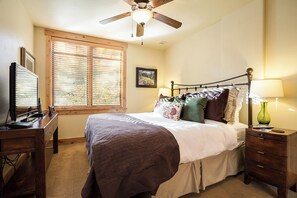 A bedroom with a bed, a desk, a television, a ceiling fan, and a window with blinds. - BL6115 | Unique and Beautiful Getaway | Heated Garage| Hot Tubs | Air Chilling (Steamboat Springs)