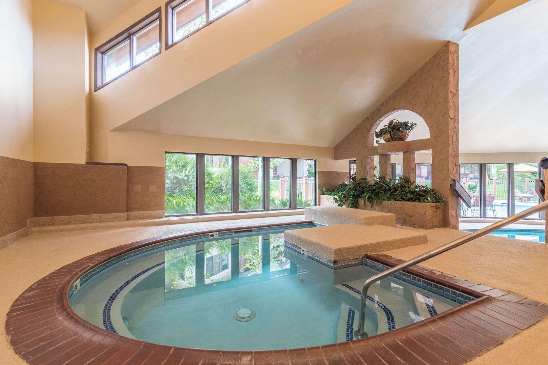 A large indoor swimming pool with clear views of the outside.