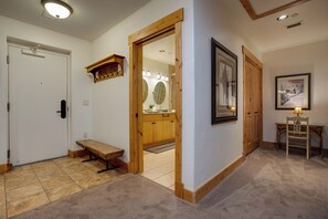 A hallway with a bench, wooden door, and a framed picture on the wall. - BL6118 | Perfect Getaway | 10 Hot Tubs | Short Walk to Slopes | Air Chilling (Steamboat Springs)