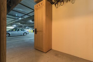 Eine Holztür, die zu einer Parkgarage führt, in der ein Auto steht.