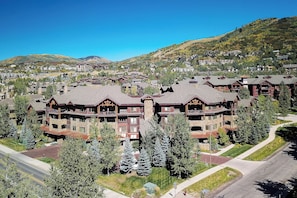Multi-unit alpine resort property nestled in a mountainous neighborhood with surrounding residential buildings visible across the hillside under clear blue skies. - BL6201 | Perfect for the Family | 4 Pools | Air Chilling | Close to Slopes (Steamboat Springs)