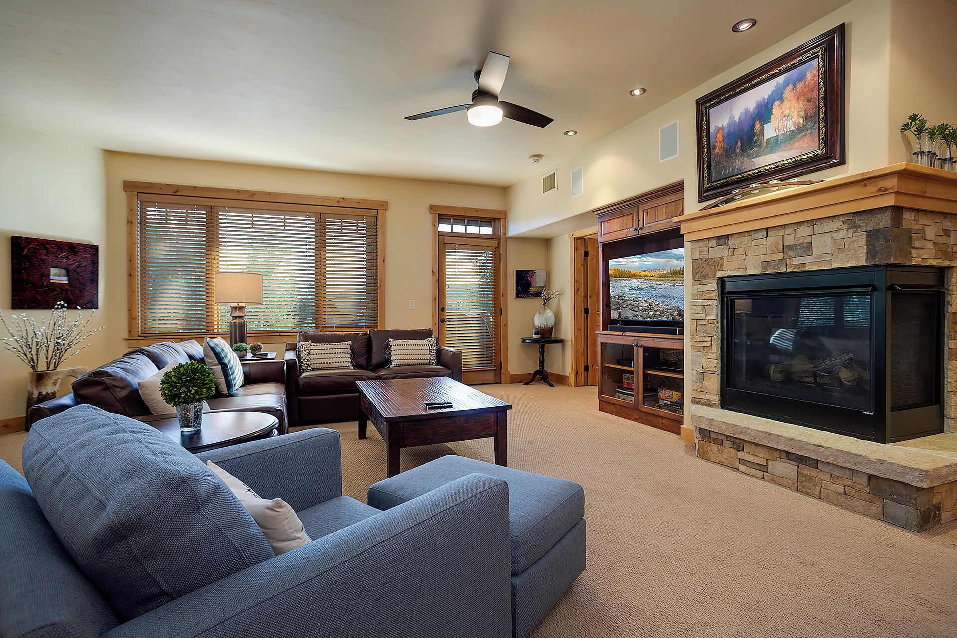 Settle into your spacious living room, where a cozy stone fireplace and plush seating invite you to unwind after a day of adventure. Warm wood accents and mountain views create your perfect retreat.