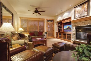 A living room with a fireplace, television, and comfortable seating. - BL6203 | Beautiful Sunset Views| 10 Hot Tubs | Air Chilling | 4 Pools (Steamboat Springs)