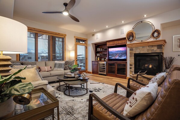 A living room with a fireplace, a television, and a ceiling fan. - BL6205 | Unparalleled Luxury at Bear Lodge | Close to Skiing | Air Chilling (Steamboat Springs)