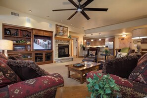 A cozy living room with a fireplace, a television, and a ceiling fan. - BL6209 | Mountain Views | 4 Pools | 10 Hot Tubs | Air Chilling | Close to Mtn (Steamboat Springs)