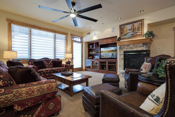 A spacious living room with a fireplace, comfortable seating, and a television. - BL6209 | Mountain Views | 4 Pools | 10 Hot Tubs | Air Chilling | Close to Mtn (Steamboat Springs)