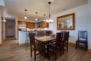 A modern kitchen with wooden cabinets, a central island, and pendant lighting. - BL6303 | Semi Private Roof Top Patio | Unreal View | 4 Pools| Air Chilling (Steamboat Springs)