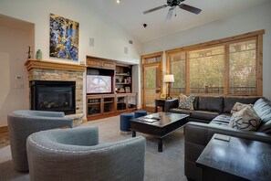 A living room with a fireplace, television, and seating area. - BL6304 | Private Roof Top with Hot Tub | Stunning Condo | Air Chilling | Pools (Steamboat Springs)