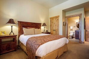 A bedroom with a large bed, two bedside lamps, a wooden headboard, a nightstand, and a wooden wardrobe. - BL6304 | Private Roof Top with Hot Tub | Stunning Condo | Air Chilling | Pools (Steamboat Springs)
