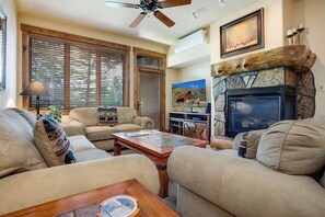 A living room with a fireplace, a television, and a ceiling fan. - CL3101 | Comfortable Mountain Vibes | A/C | 10 Hot Tubs | 4 Pools (Steamboat Springs)