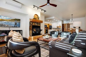 Un salon moderne avec une cheminée, des canapés en cuir et un coin repas.