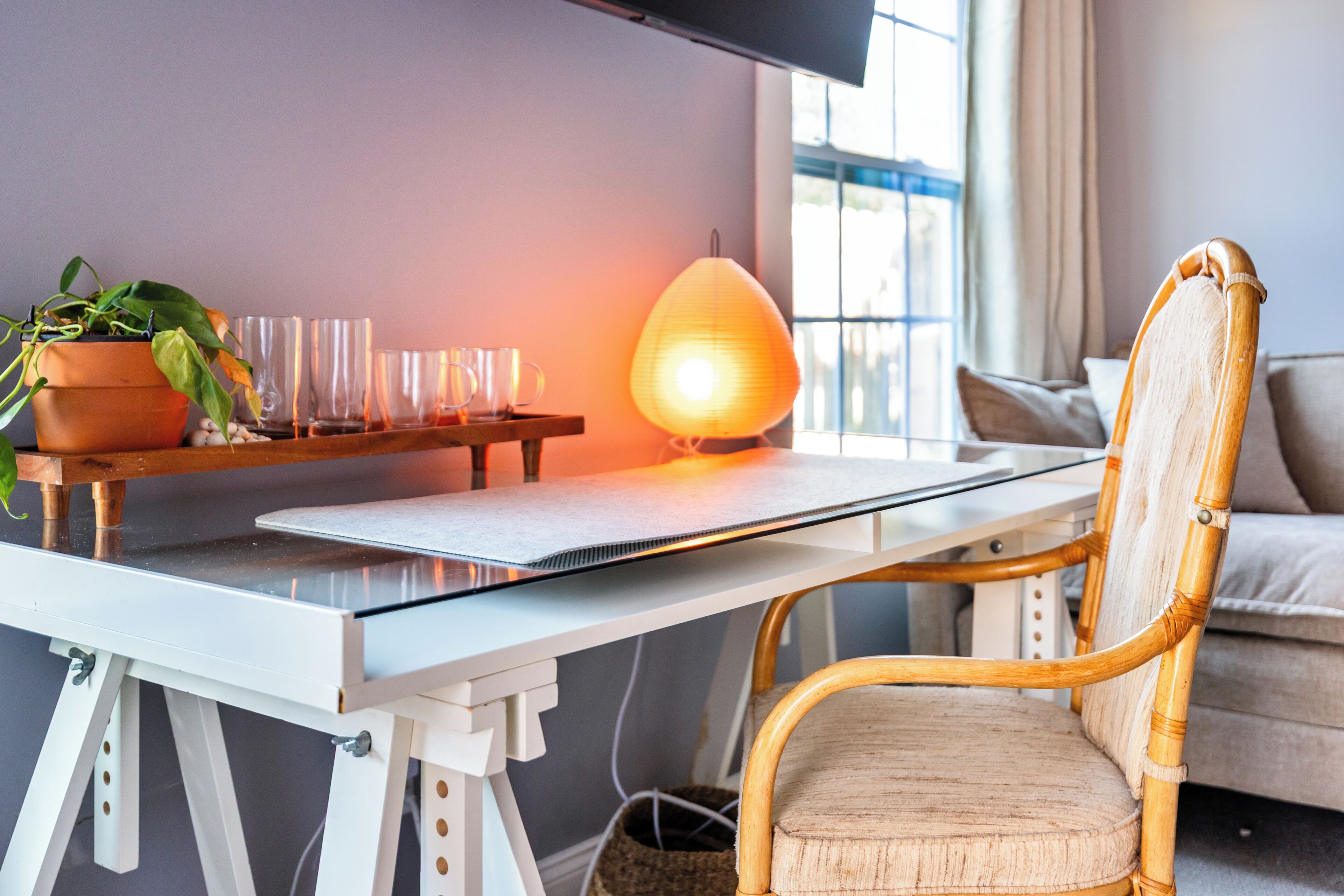 Un espacio de trabajo moderno con escritorio, silla y planta en maceta.