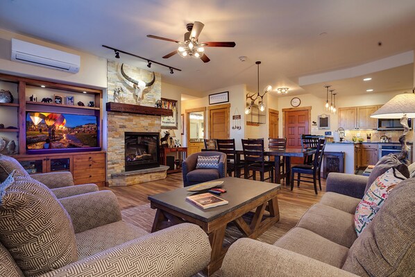 A cozy living room with a fireplace, a dining area, and a kitchen. - CL3110 | Gorgeous Mountain Home with Updates | A/C | Close to Skiing (Steamboat Springs)