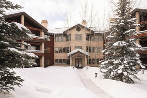 Un immeuble à plusieurs étages dont l’entrée principale, située au centre, est marquée du numéro « 1825 ».