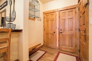 A wooden door with a sign above it, a bench, and a wall-mounted rack with items. - CL3204 | Updated Condo with Beautiful Décor | A/C | Close to Mtn (Steamboat Springs)
