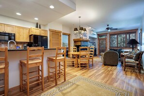 A spacious kitchen with wooden cabinets and a dining area with a wooden table and chairs. - CL3205 | Great Family Condo | A/C | 10 Hot Tubs | Close to Slopes (Steamboat Springs)