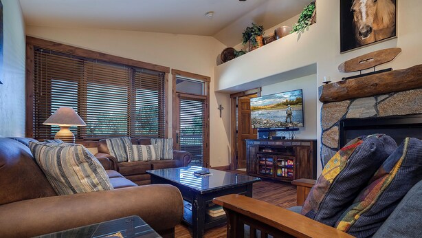 Una sala de estar acogedora con chimenea, asientos cómodos y televisor.