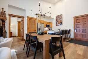 Eine moderne Küche mit Holzausstattung, einer zentralen Kochinsel und einem Essbereich mit Esstisch und Stühlen.