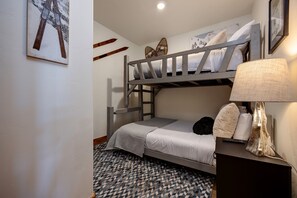 A bunk bed room with a patterned floor, a lamp, and a painting on the wall. - CL3306 | Top Floor with Vaulted Ceilings | 10 Hot Tubs | A/C | Pools (Steamboat Springs)