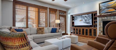 Sink into plush seating surrounded by rich wood tones and modern comforts, including a stone fireplace and entertainment center, perfect for relaxing evenings together.