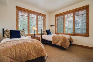 Ein Schlafzimmer mit zwei Betten, Holzfensterrahmen und einem Schild an der Wand.