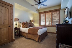 A bedroom with a bed, a ceiling fan, a window with blinds, a nightstand with lamps, and a wooden wardrobe. - EL5110 | Private Hot Tub | 4 Pools | Air Chilling | Close to Skiing (Steamboat Springs)