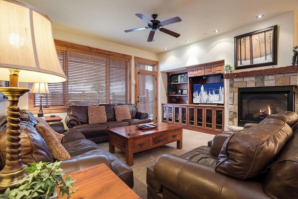 A living room with leather sofas, a coffee table, a fireplace, and a television. - EL5110 | Private Hot Tub | 4 Pools | Air Chilling | Close to Skiing (Steamboat Springs)