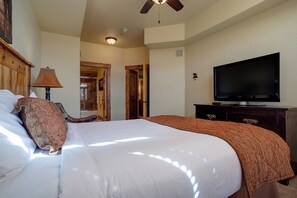 Ein Hotelzimmer mit einem großen Bett, einem Fernseher und einem Deckenventilator.