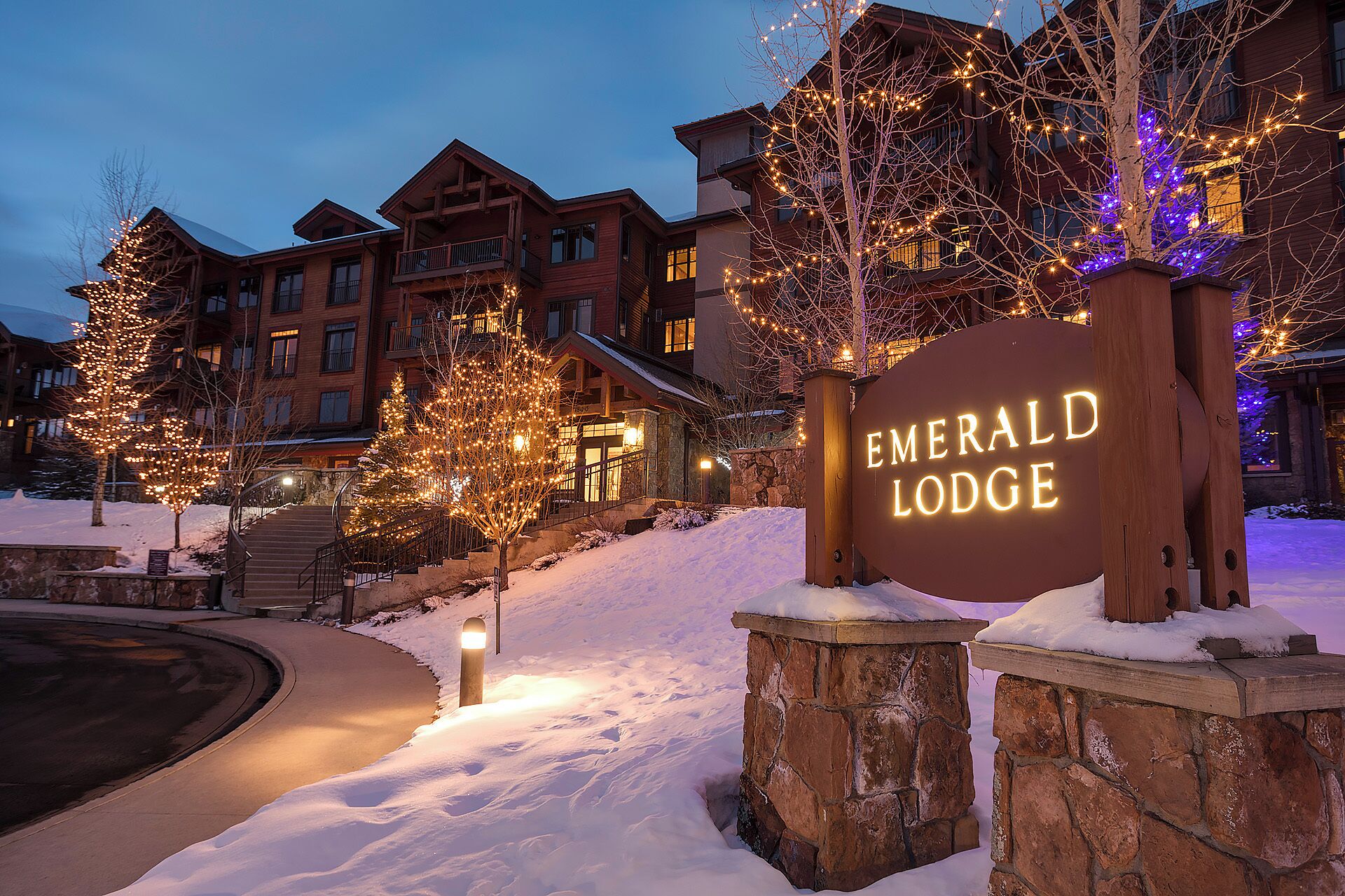 A snow-covered landscape with a sign for Emerald Lodge.