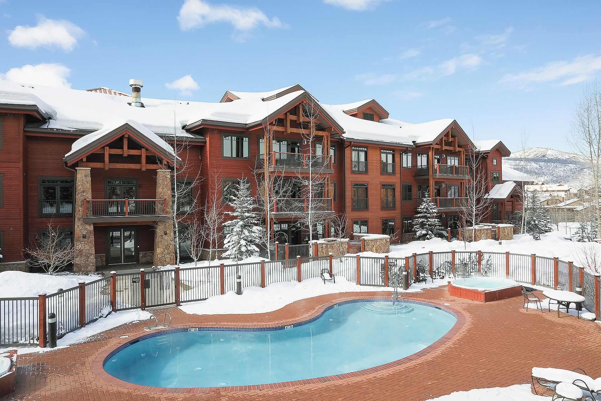 A large building with a pool and snow-covered surroundings.