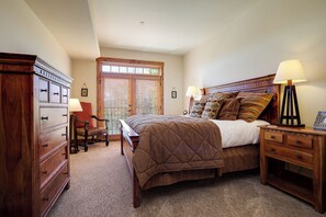 A bedroom with a large bed, wooden furniture, and a window with blinds. - EL5204 | Ultimate Mountain Getaway | Air Chilling | Close to Mtn | Pools (Steamboat Springs)