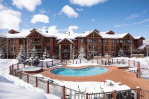 A resort with a pool, snow-covered landscape, and multiple buildings with balconies. - EL5204 | Ultimate Mountain Getaway | Air Chilling | Close to Mtn | Pools (Steamboat Springs)