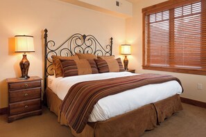 A neatly made bed with a striped blanket, two bedside lamps, and a wooden nightstand with a drawer. - EL5206 | Relax in Luxury | Spacious and Amenities Galore | Air Chilling | Pool (Steamboat Springs)