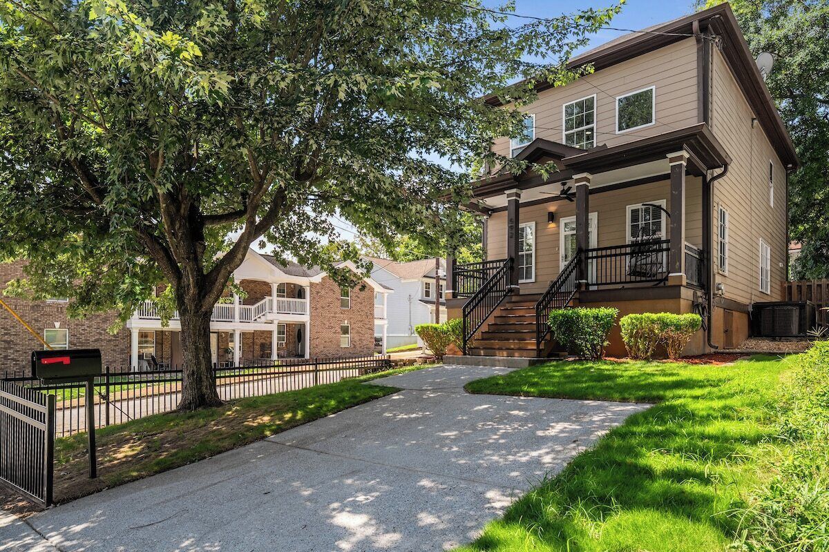 A residential building with a front porch, a staircase, and a mailbox.