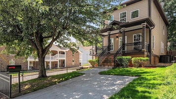 A residential building with a front porch, a staircase, and a mailbox.