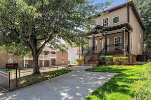 A residential building with a front porch, a staircase, and a mailbox. - The Buford Luxe | Game Room + Office | 3BR (Atlanta)